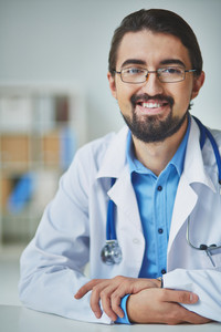 Portrait of smiling male doctor looking at camera at workplace Royalty ...