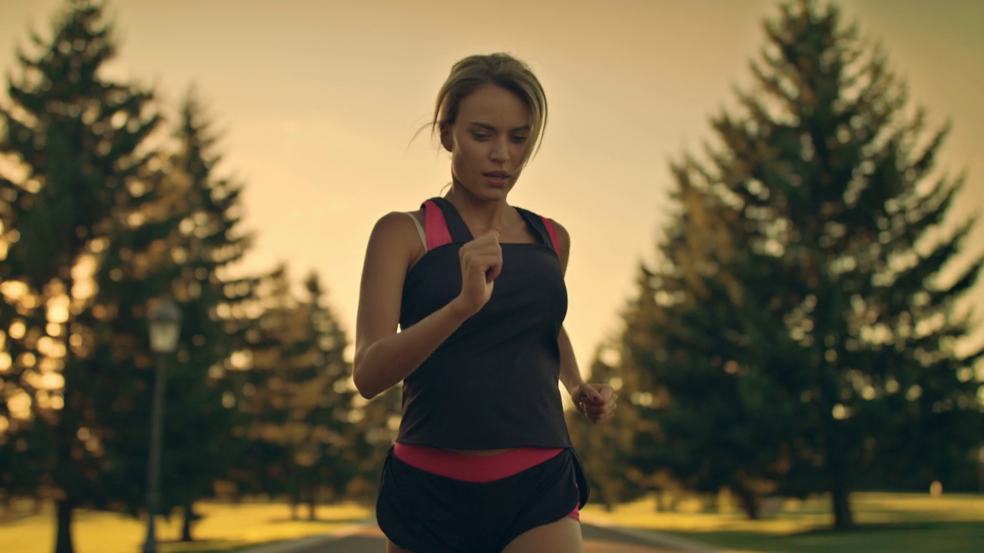 Sport woman running in park at sunset. Tired runner stop for break at park  road. Athlete woman jogging outdoor. Exhausted runner girl resting after  running marathon in city park