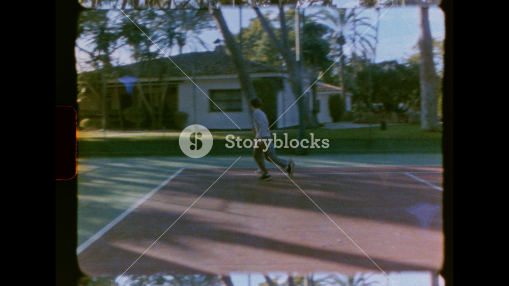 Vintage 8mm film captures a boy and girl playing basketball on a backyard court. Authentic home movie footage shows siblings having fun