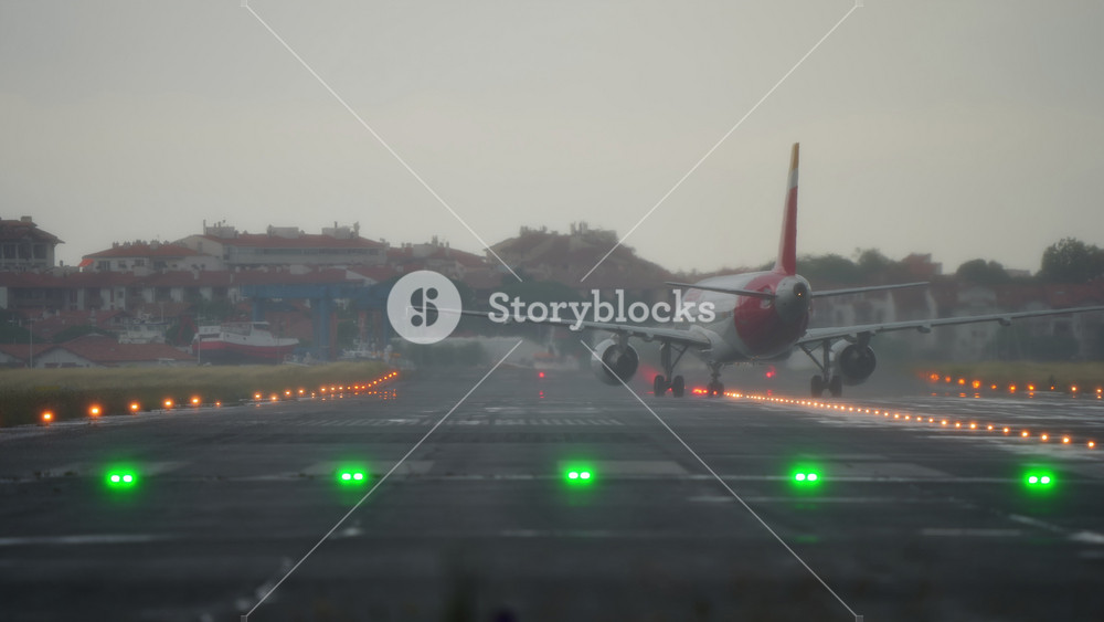 SAN SEBASTIAN, SPAIN - FEBRUARY 13, 2026: Iberia Airbus A320 is taxiing after landing on a wet runway at San Sebastian airport EAS in rainy