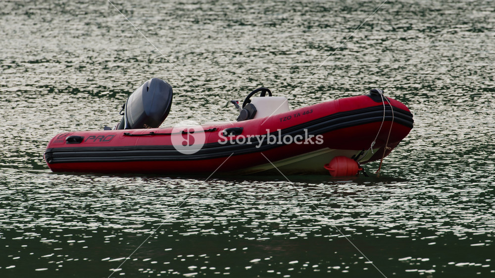 Vasiliki, Greece - September 27 2023: An inflatable rescue boat tied to a buoy in the calm waters of the Ionian Sea in Vasiliki bay, Lefkada, Greece.