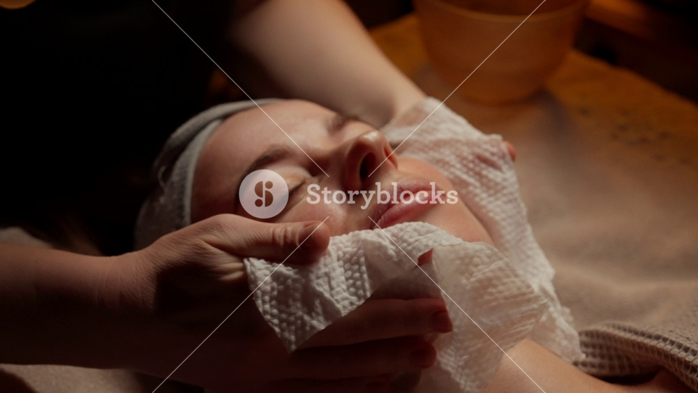 Tranquil spa facial treatment with soothing warm towel cleansing and serene relaxation as a woman enjoys peaceful skincare therapy on a