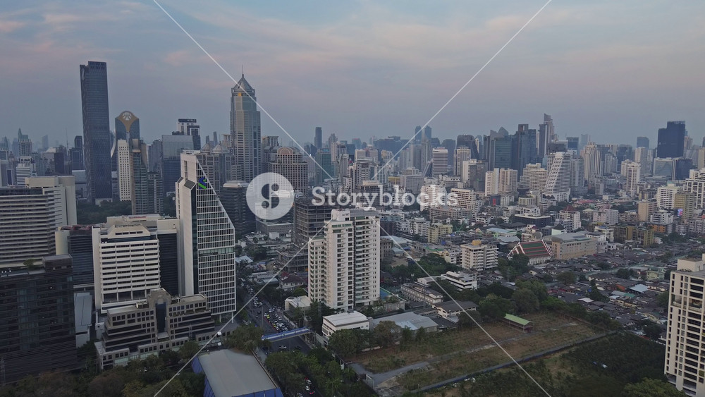Aerial view of Bangkok city skyline in dusk after sunset. Urban and office buildings in business district, Thailand, 4k