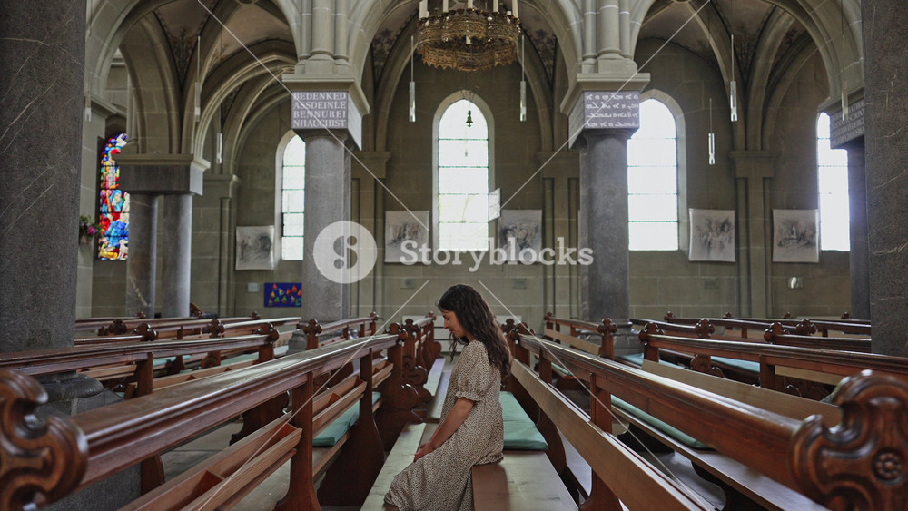 Woman Praying Inside Historic Gothic Church in Bern Switzerland Spiritual Faith. Filmed on 18 June 2025. Editorial footage