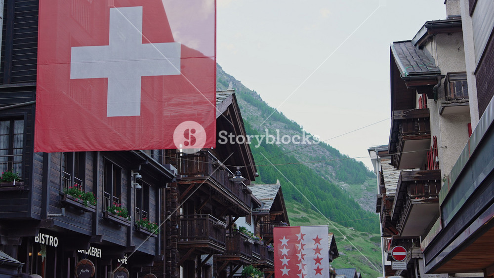 Swiss and Valais Flags in Zermatt, Switzerland Mountain Village Scene.Filmed on June 12,2025.Editorial footage.Filmed on June 12,2025.Editorial footage