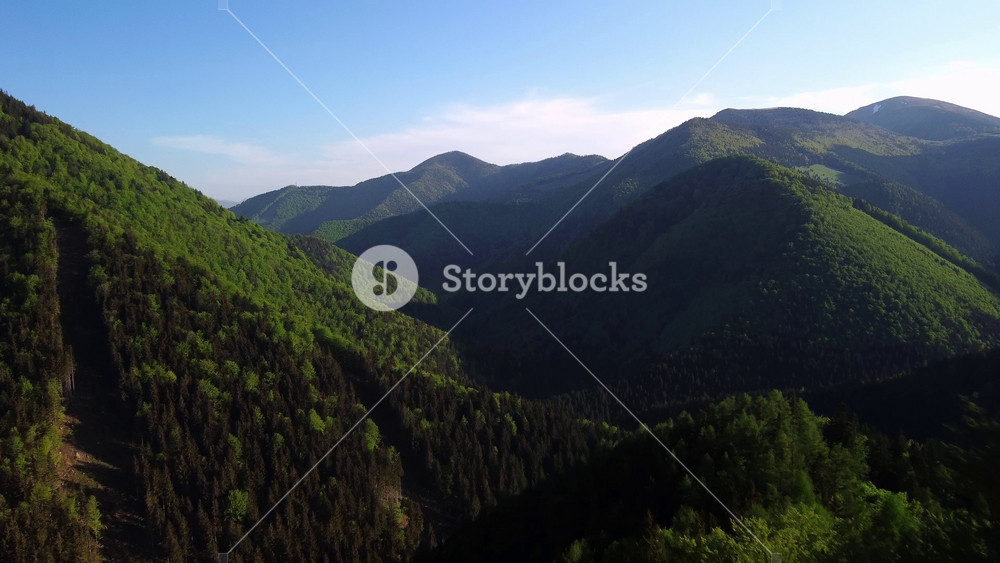 Immerse yourself in the peaceful serenity of breathtaking lush green mountains stretching under an expansive clear blue sky. This is your perfect escape into the beauty of nature