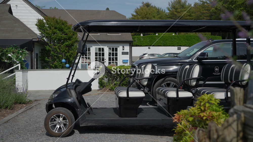 NEW YORK, USA - MAY 20, 2025: A sleek and stylish black golf cart is parked in an incredibly beautiful outdoor showcasing its modern design