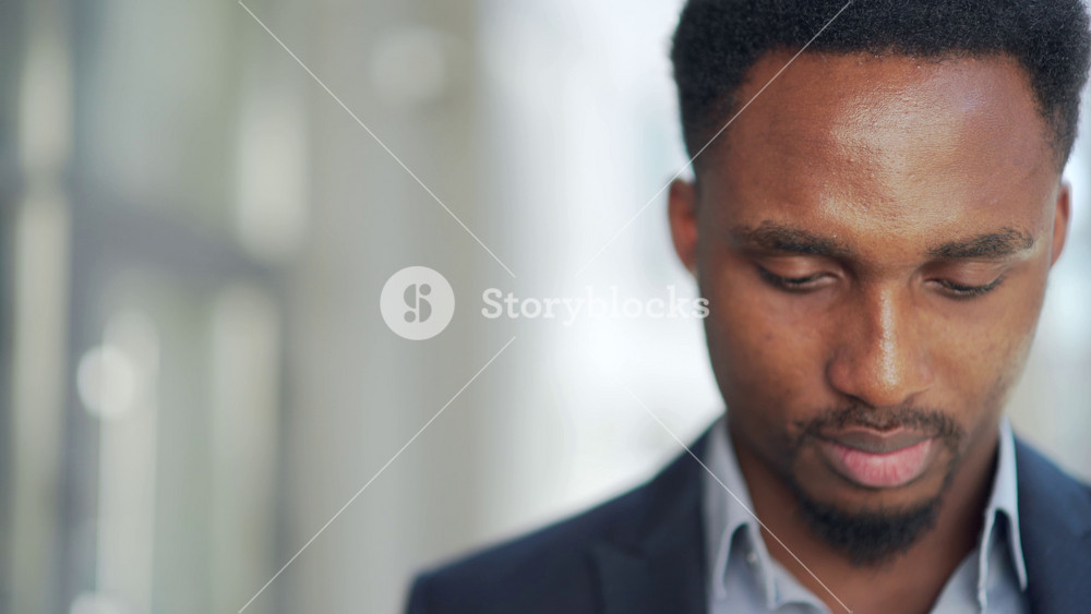 Portrait young confident successful African American businessman looking at camera close up face Serious black business man urban blurred background outdoor Male a formal suit outside copy space text