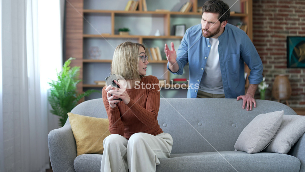 Angry jealous husband suspects his wife of infidelity who uses mobile phone. Quarrel due to jealousy caused by chatting and flirting via social media. Woman has an addiction to smartphone and Internet