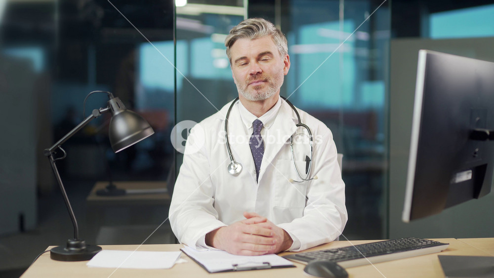 Portrait Mature Doctor Online Consultation With Patient On Video Call talking At Hospital Prescribes medications remotely. physician man gives advice counseling helpline look at camera. webcam view