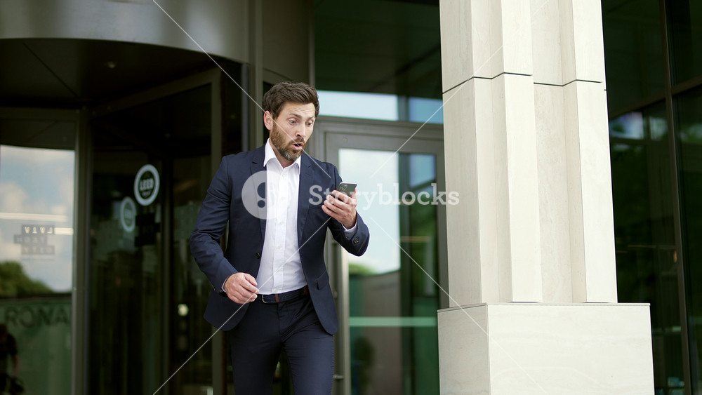 Man rushes to work. Late business meeting. Worried businessman on the way to office. Male in suit in hurry running Deadline. Time management. Busy Lifestyle rush and looks at the smartphone