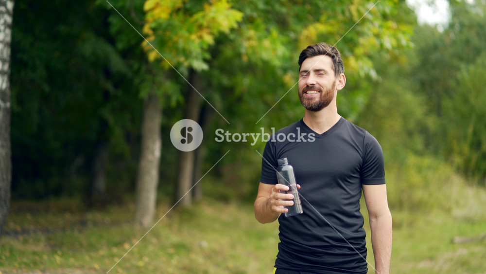 Tired exhausted dehydrated Athlete man runner drinking water bottle after workout. Sports bottle drink. male sportsman. runner sweaty and thirsty after difficult jogging outdoors in city park