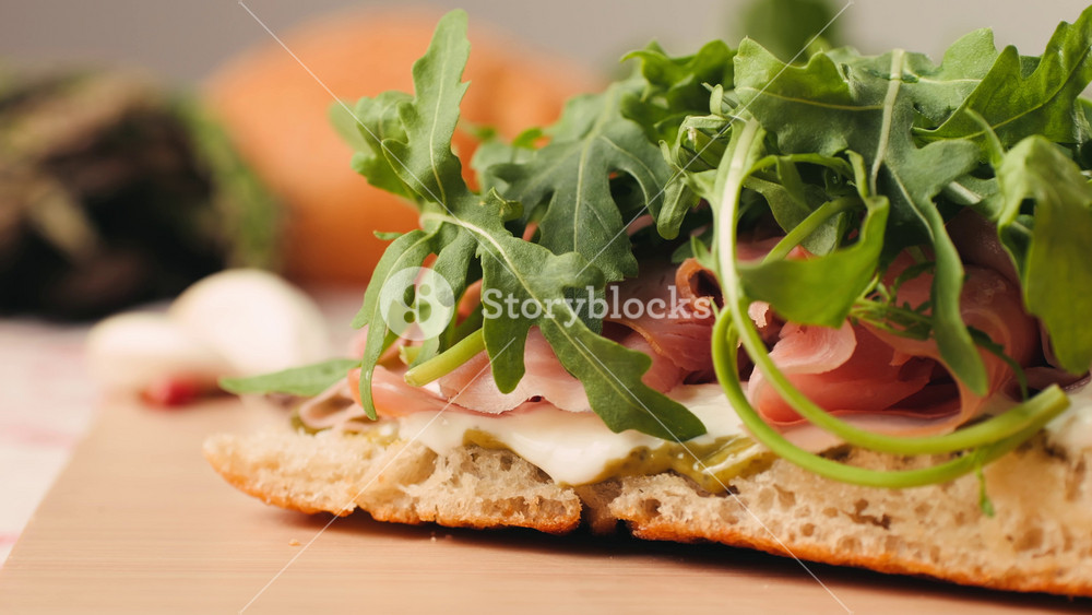 Mortadella ham sandwich, Traditional italian focaccia filled with thin pesto slices of mortadella, served by chef man in cafe restaurant