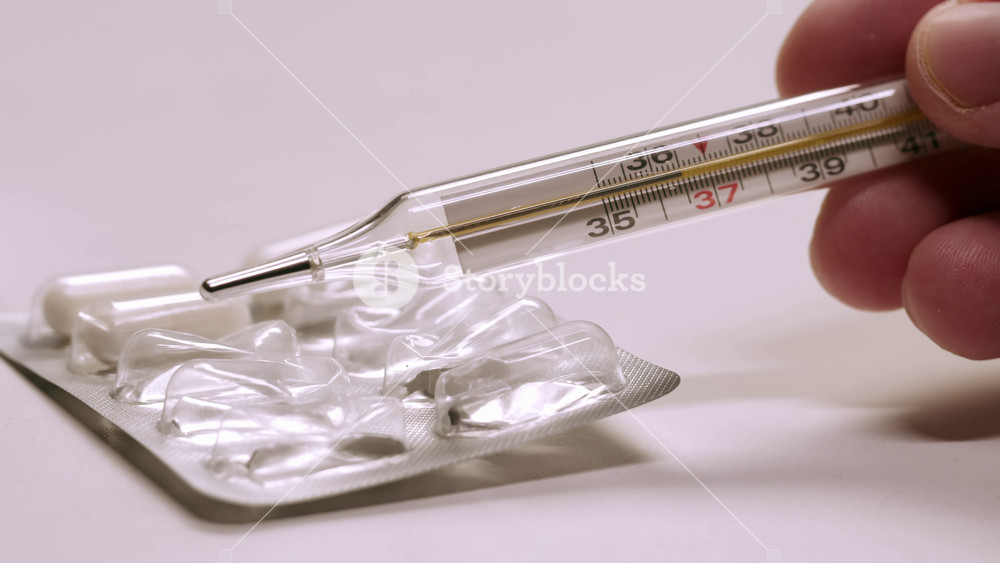 Woman holds mercury thermometer in her hands to measure body temperature, disease, Doctor or nurse, sick patient. Fever from Covid-19 virus