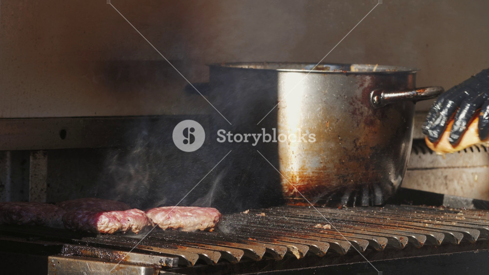 Cooking beef and pork patty with cheese for burger on black grill close-up. Smash fat hamburgers street fast food outdoor. Food concept.