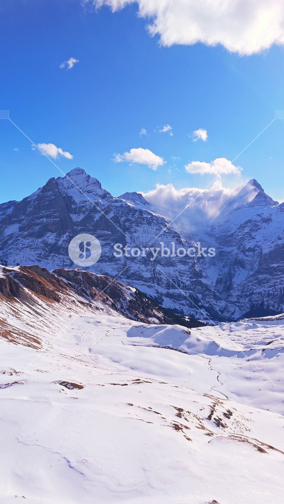 Wetterhorn and Schreckhorn Mountains on Sunny Winter Day. Swiss Alps. Switzerland. Aerial Drone Shot. Moving Backwards