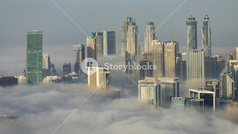 Timelapse of a rare phenomenon of a mist of clouds below the skyline of dubai from a unique high vantage point in the early morning