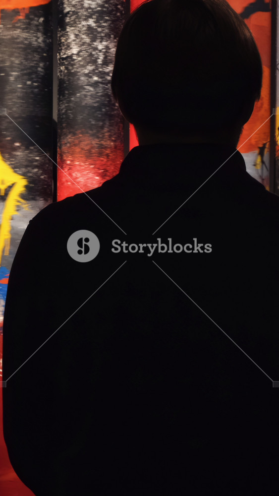 View from the back of man looking at the colorful paintings rotating on the rolls in the museum of Modern Art. Concept. Gallery in Saint