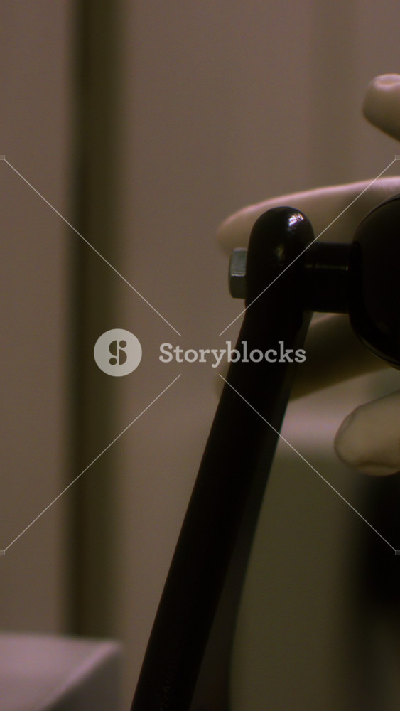 Close-up view of hand in white protective glove turning the large black handle of some metal box or storage. Stock footage. Vault door