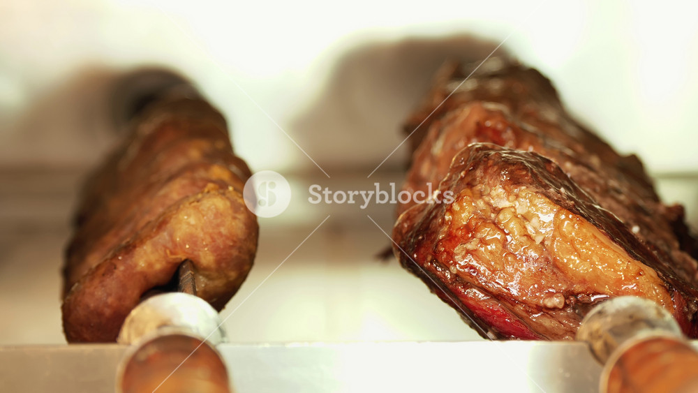 Traditional shish kebabs roasting over hot charcoal with smoke at an outdoor culinary festival. Barbecue cooking atmosphere for foodies.