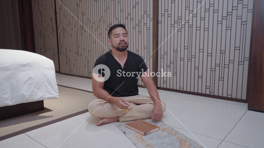 Southeast Asian Muslim Man with Black Shirt Salah Salat Zikr Holy Quran Reading Islam Prayer Islamic Ritual in Bed Room