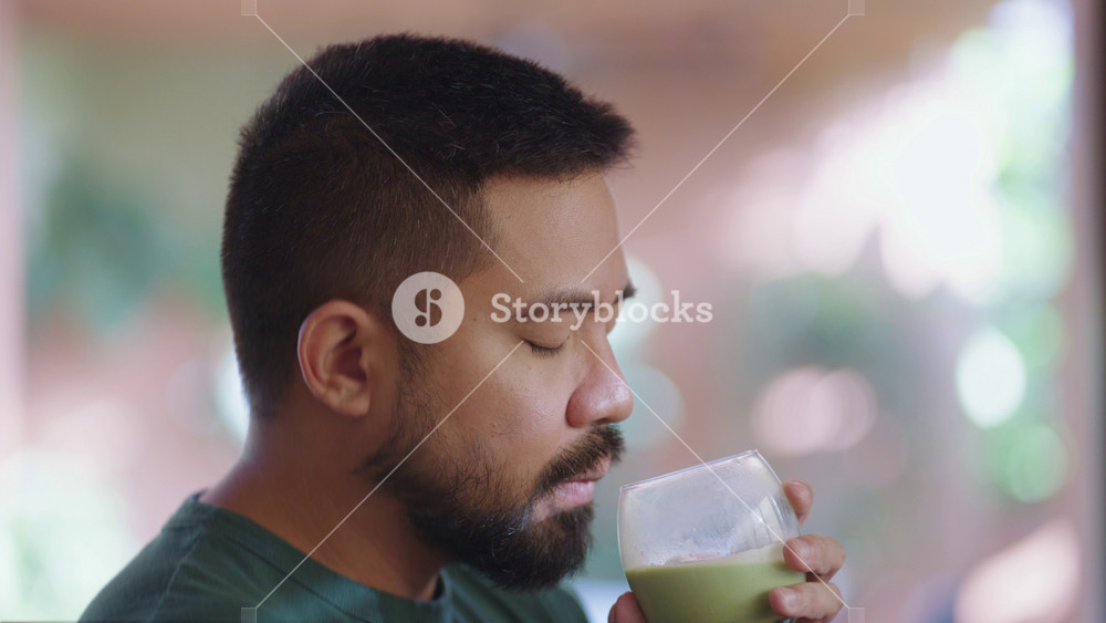 Relaxed scenes of man sipping homemade matcha latte at home. Natural lifestyle moments showing calmness, daily ritual, and enjoyment of a traditional green tea drink.