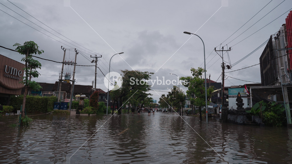 Bali, Indonesia - February 24, 2026: Flood conditions on Jalan Dewi Sri Kuta, Bali after heavy rain on Feb 24, 2026. Streets submerged with vehicles, pedestrians, and urban activity during severe flooding.