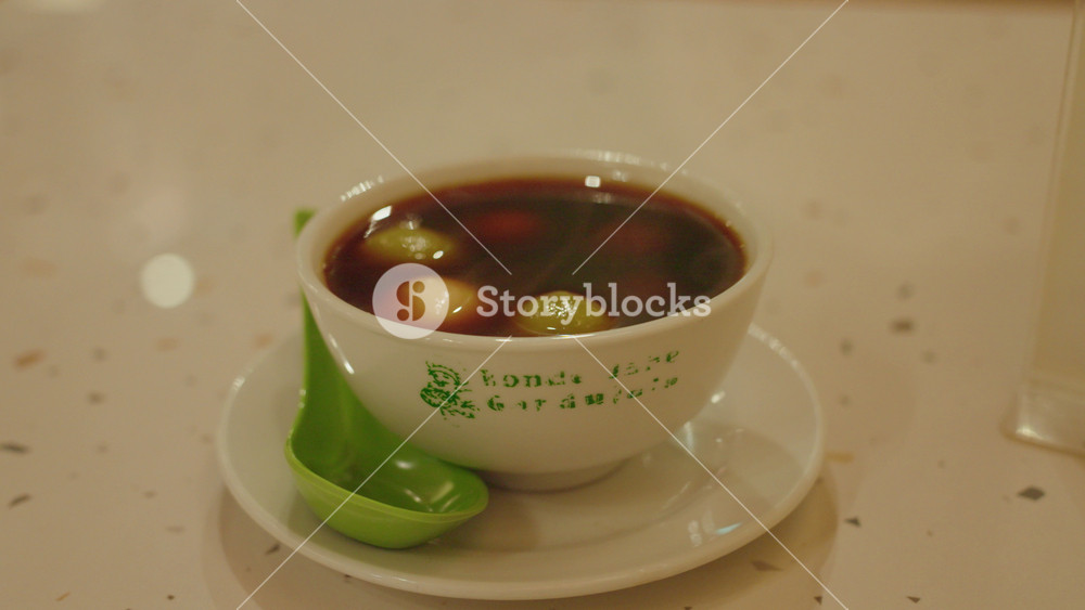 Preparing a warm bowl of ginger ronde in Bandung. Ronde is a traditional Peranakan dessert popular in Bandung, Indonesia, made with glutinous rice balls served in sweet ginger broth.