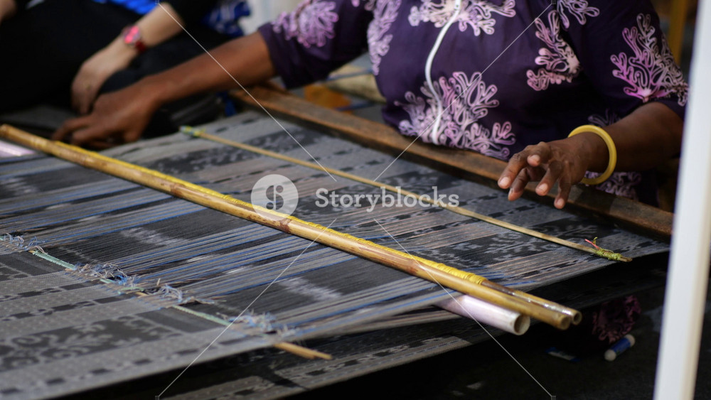 Making tenun ikat flores, Indonesia. An Indonesian woman weaving traditional flores fabric. Traditional weaving cotton in Indonesia.