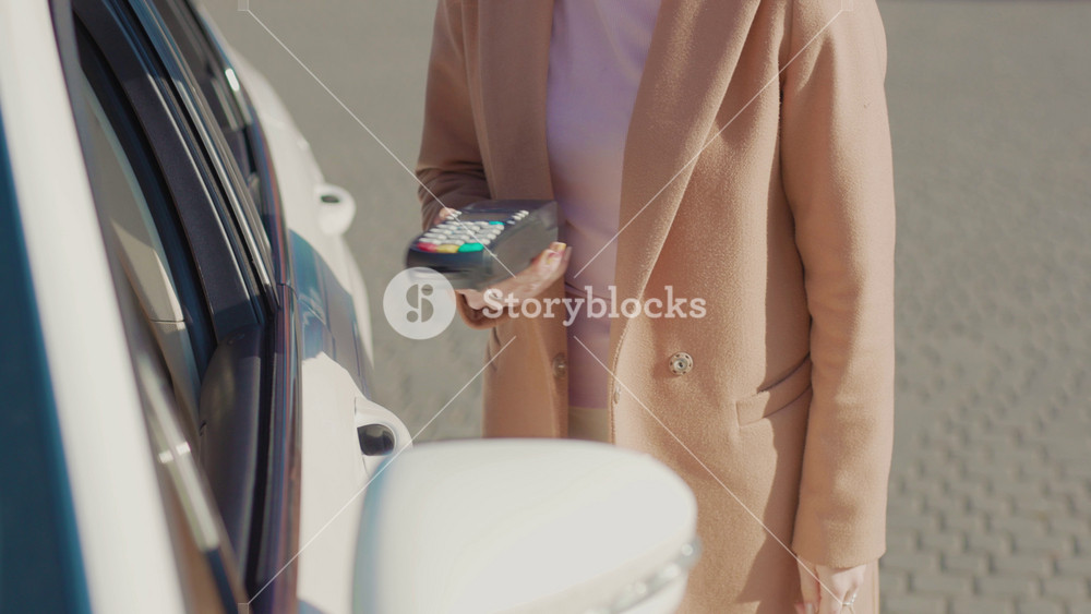Slow motion woman making payment transaction with his mobile phone at car buy food finance money banking business electronic terminal