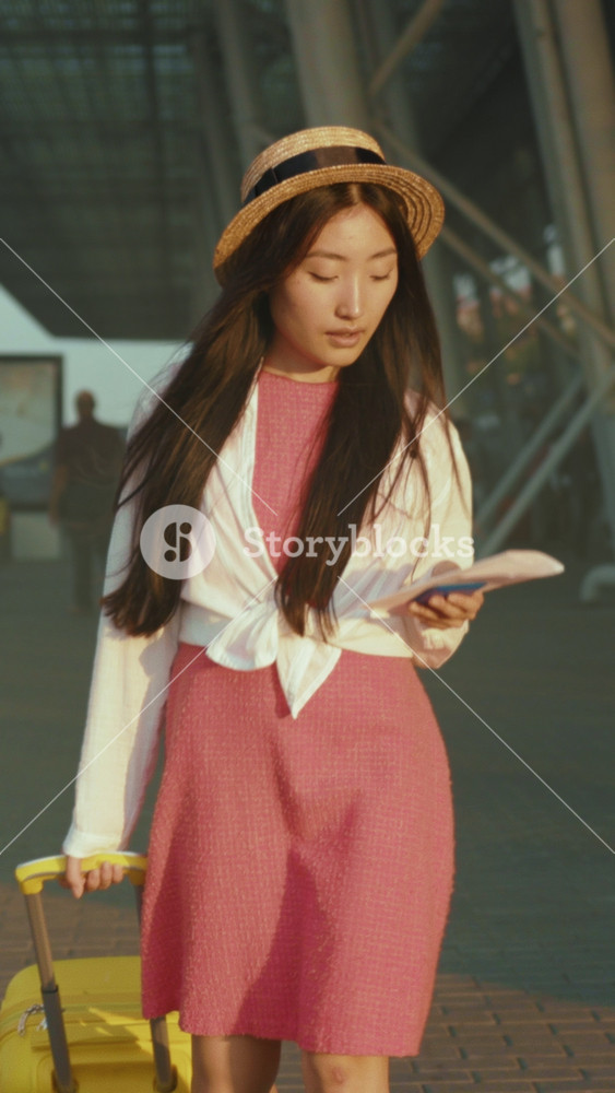 Traveler reviews route, Stylish female traveler meticulously reviews her plans and destination choices at airport