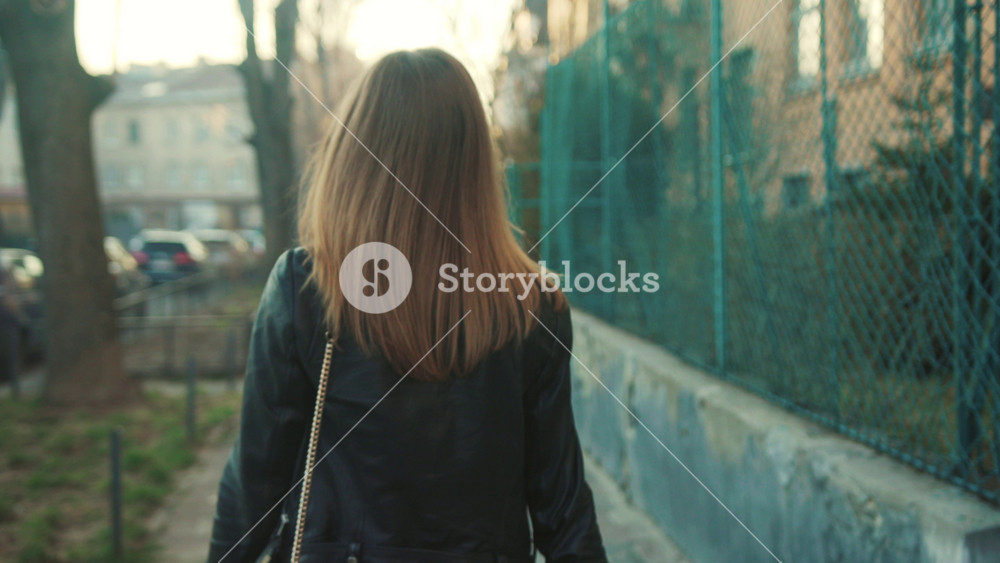 Flawless playful Caucasian girl walking through the street looking around. Young woman looking at camera, smiling. Morning in city. Outdoors