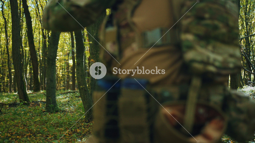 Shot of armed Ukrainian soldier with weapon moving through forest. Footage of man in bulletproof vest. Armed forces of Ukraine. Martial law