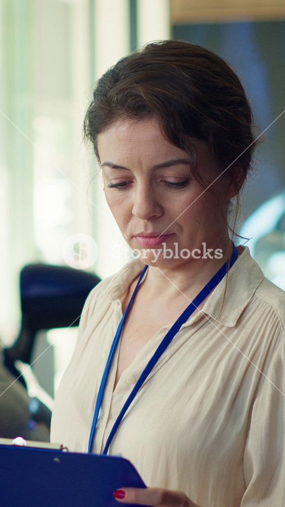 Vertical video Portrait of car showroom salesperson tasked with helping customers evaluate potential automobile option. Upbeat saleswoman