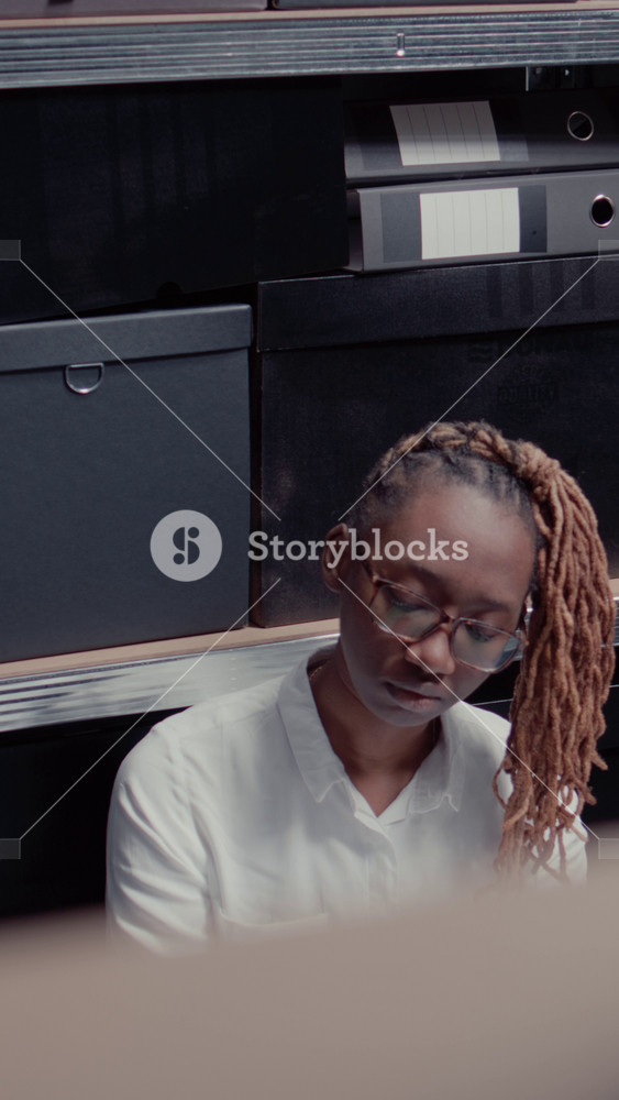 Vertical video: Woman officer reading witness statements in incident room, examining private records and law enforcement evidence. Private