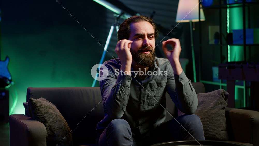 Livid supporter watching sports match, exasperated by awful team performance, throwing pillows to TV screen. Angry man looking at football