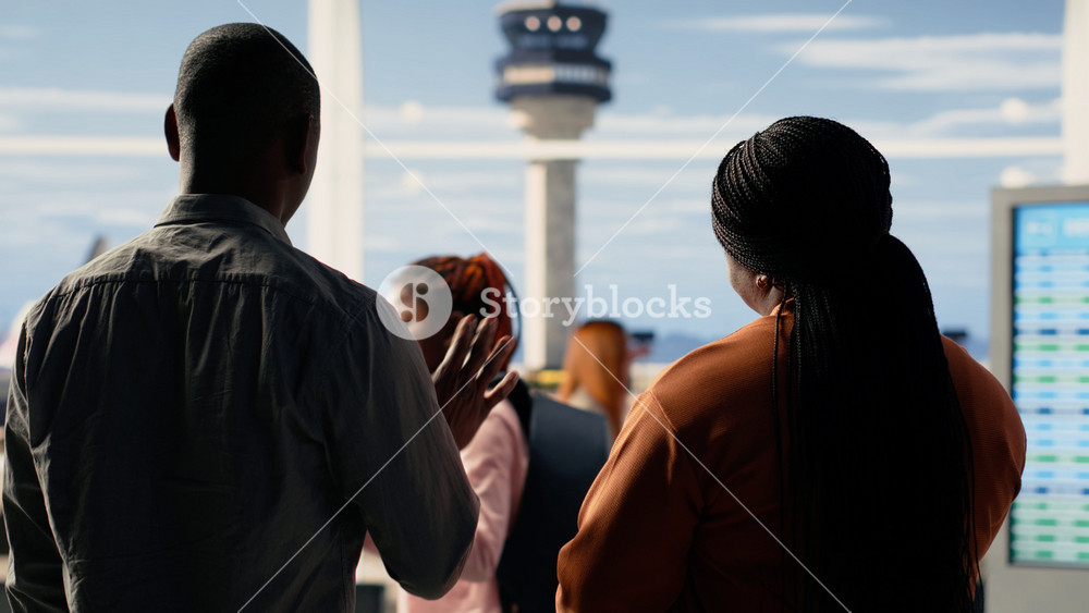 Sad yet proud parents waving goodbye during emotional send-off with their child at the airport. Teenager walking toward gate for boarding