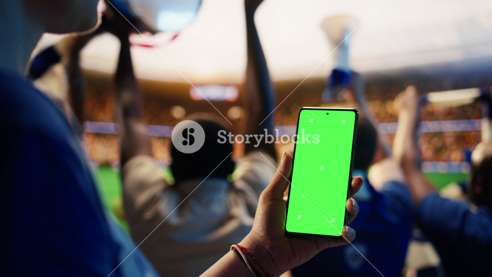 Close up of isolated screen smartphone used by football supporter in stadium to follow live scores. Soccer fan checks betting app on mockup