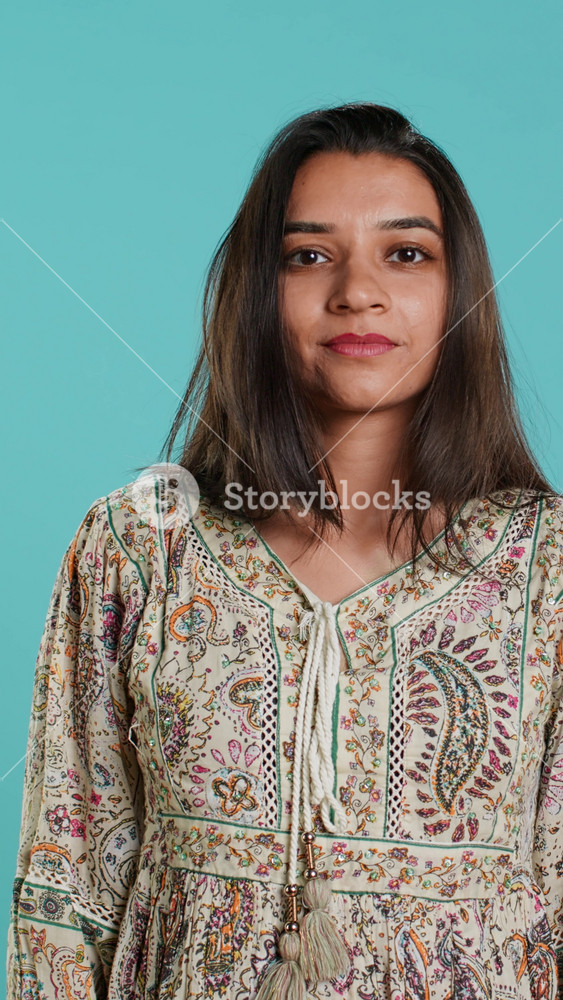 Vertical video Portrait of optimistic indian woman wearing colorful clothes with positive facial expression smiling, looking pleased. Calm