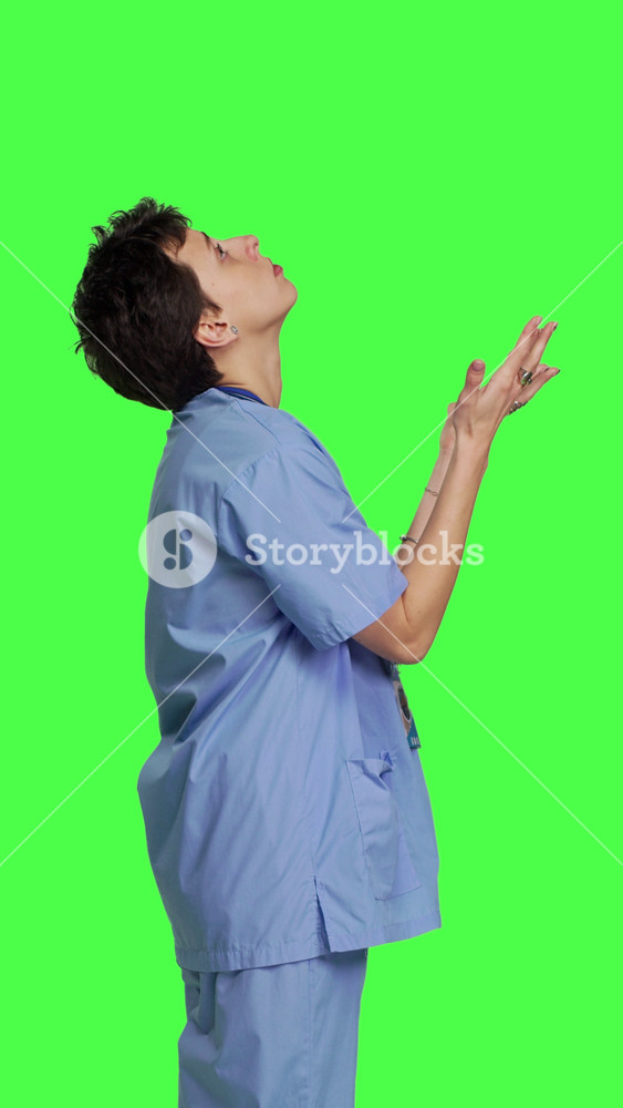 Profile Hospital nurse worshipping God by prayer against greenscreen backdrop, praying to jesus christ and having hope in christianity and