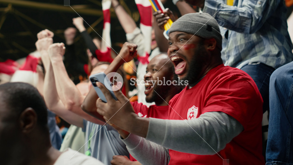 Excited football supporter celebrating live bet win on his phone, dramatic soccer match in a stadium. Happy fan reacts with shock and