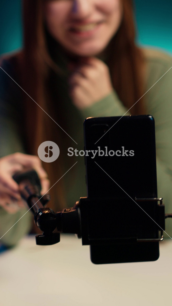 Vertical video Focus on smartphone used by content creator in blurry background to film room tour. Close up of mobile phone used by teenage