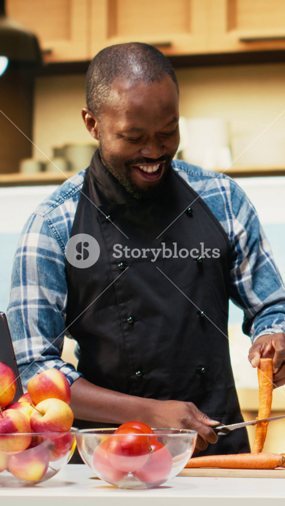 Vertical Video African American couple chopping fresh bell peppers and carrots for organic salad, preparing vegetarian food at home. Lovers