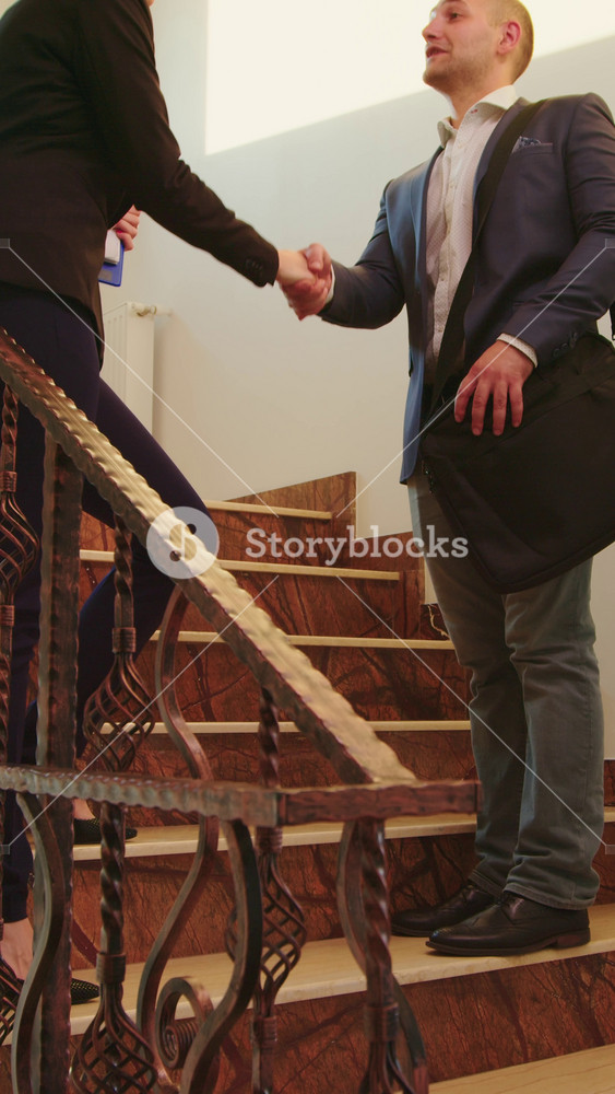 Business people meeting on stairs in finance corporate company shaking hands and talking. Team of professional businesspeople working