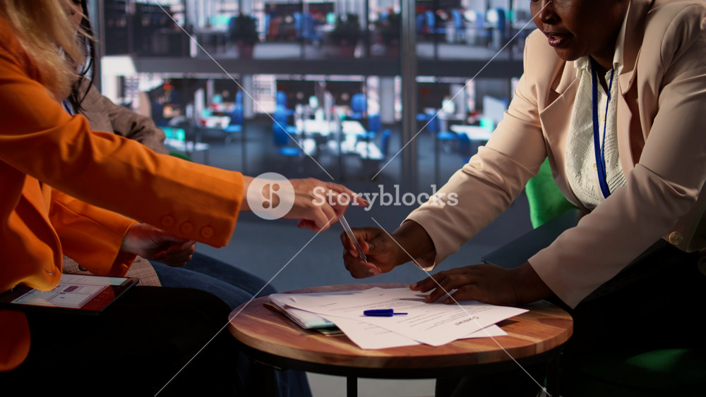 Team of empowered businesswomen in a corporate meeting making a deal, signing a contract that signifies business growth. Female leaders