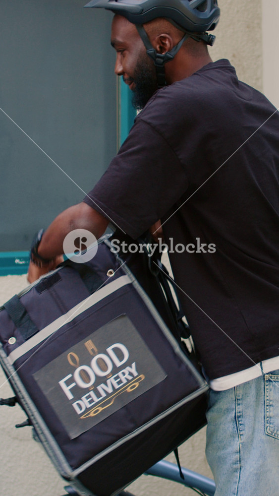 Vertical video: Delivery service employee delivering lunch meal order to client, man giving woman paper bag with restaurant food. Smiling