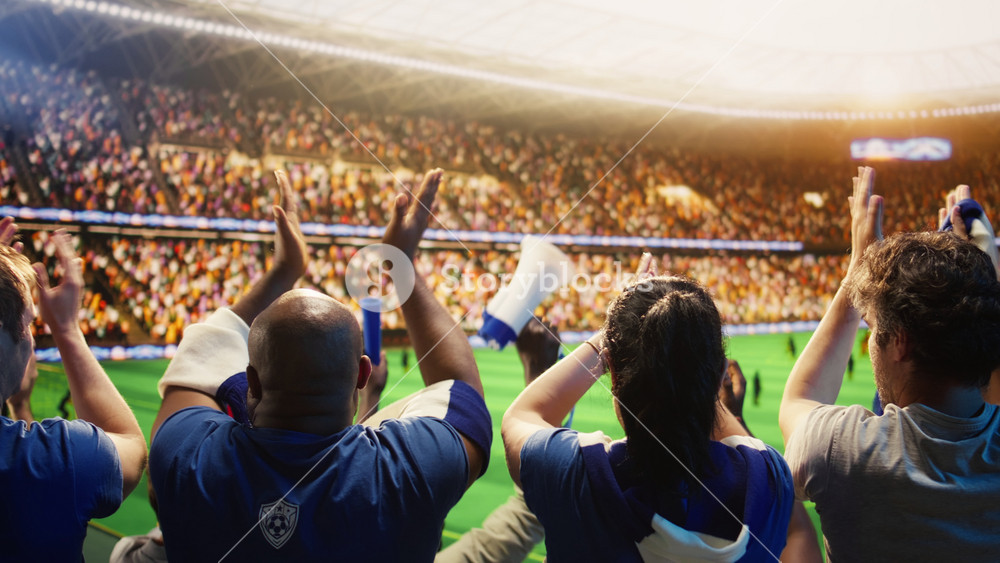 Close up of football stadium crowd applauding after entertaining play. Rear view of soccer fans clapping to motivate players running on