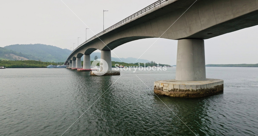 Siri Lanta Bridge spanning across water connecting Koh Lanta Noi and Koh Lanta Yai islands. Traditional fishing boats and dense coastal