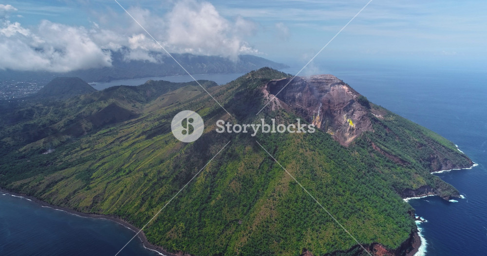 Aerial drone footage showing smoke rising from the crater of Mount Iliwerung, an active volcano located on Flores Island, Indonesia