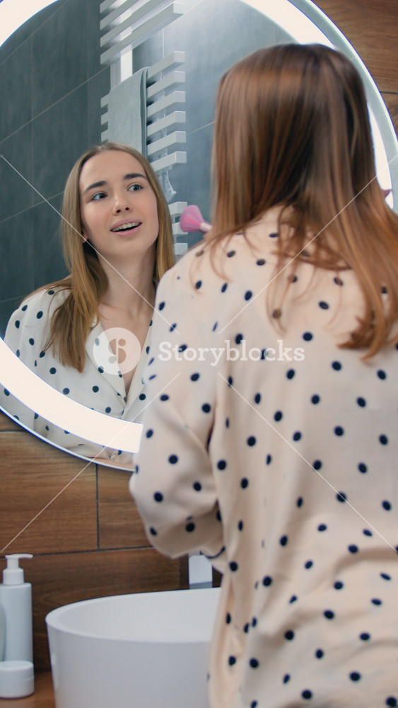 Happy woman looking in mirror touch healthy soft face skin after daily treatment. Skincare, professional care product cosmetics
